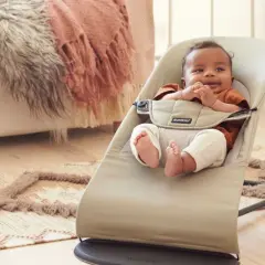 Söt bebis i babysitter. Frågan "när kan man börja använda babysitter" besvaras av att denna lilla redan njuter av den.