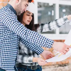 Pareja revisa planos de construcción. Saben qué se necesita para tasar una vivienda, analizando cada detalle.