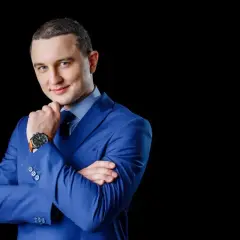 Elegancki mężczyzna w niebieskiej marynarce i krawacie, idealny przykład, zdjęcie do CV jak się ubrać.