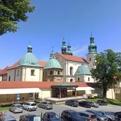 Kraków Kalwaria Zebrzydowska: imponujący zespół klasztorny z zielonymi kopułami i wieżami, otoczony parkingiem i drzewami.