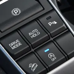 Przyciski w samochodzie: hamulec postojowy, Drive Mode, Auto Hold, asystent parkowania i system zapobiegający stoczeniu się na wzniesieniu (hill holder).