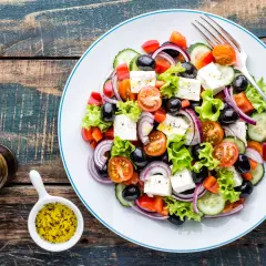 Insalata greca con feta, pomodorini, olive, cetrioli e cipolla rossa. Perfetta per una dieta leggera e gustosa.