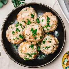 Vegane Knödel, garniert mit Petersilie, auf einem Teller. Ein köstliches veganes Knödel Rezept für ein festliches Essen.