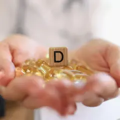 Dłonie trzymają kapsułki z witaminą D3. Jaka dawka dla psa będzie najlepsza?