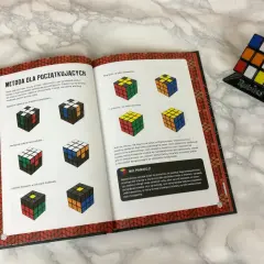 Instrukcja jak krok po kroku ułożyć kostkę Rubika. Książka z ilustracjami pokazuje etapy układania białej ściany, krawędzi i narożników.