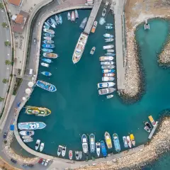 Port na Cyprze, gdzie ruch lewostronny widać na drodze obok zacumowanych łodzi.