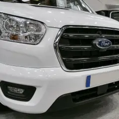 Avant d'un camping-car blanc avec le logo Ford. Ce véhicule est équipé d'un moteur Ford 2.2 TDCI, parfait pour vos voyages.