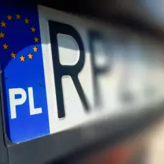 Zbliżenie na polską tablicę rejestracyjną z symbolem UE. Czas na przerejestrowanie samochodu i nowe oznaczenia.