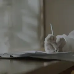 Ręka w rękawiczce pisze na papierze. Czy to notatki o tym, **kadm co to** jest i jego wpływie na zdrowie?