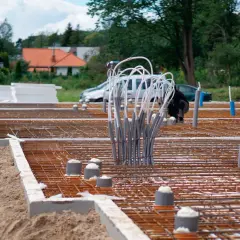Budowa fundamentów domu: zbrojenie, rury i izolacja.