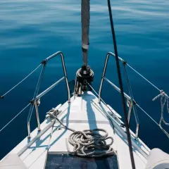 Prua di una barca a vela su un mare blu calmo. La prevalenza di una pompa è un concetto che non si applica a questa immagine.