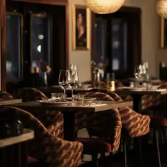 Mysig atmosfär på en av Stockholms nya restauranger. Dukade bord med glas och bestick, ombonade stolar och konst på väggarna.
