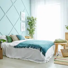 Sypialnia w stylu feng shui, z dominującymi kolorami zieleni i błękitu, tworzy spokojną atmosferę.