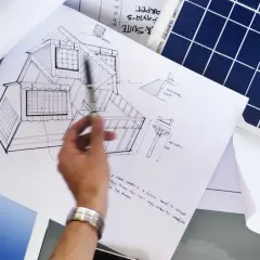 Rysunek domu z panelami fotowoltaicznymi na dachu i obok panel słoneczny. Projekt uwzględnia kąt nachylenia paneli fotowoltaicznych.