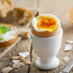 Un huevo duro 8 minutos con la yema líquida, listo para disfrutar con pan tostado y mantequilla.