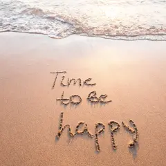 Sand mit Wellen und der Aufschrift "Time to be happy". Ein Moment des selig seins.