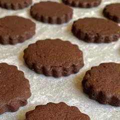 Deliziosi biscotti senza burro al cacao, con bordo ondulato, pronti per essere gustati.