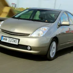 Złoty Toyota Prius 2 jedzie po moście, rejestracja WW 320WE.