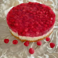 Himbeer-Curd-Torte mit frischen Himbeeren und glänzender Tortenguss-Schicht auf einem cremigen Boden. Ein Genuss für Augen und Gaumen.