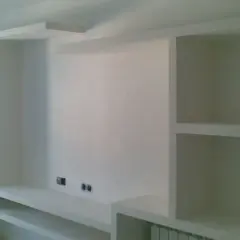 Parete attrezzata fai da te in cartongesso, con vani a giorno e mensole, pronta per accogliere TV e oggetti.