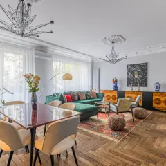 Elegancki salon z zieloną kanapą i jadalnią, idealny do zamieszkania. Ten dom na sprzedaż w Krakowie zachwyca stylem.