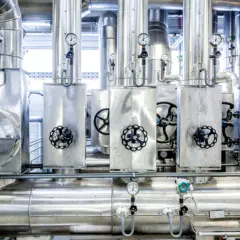 Wielkie, lśniące rury i zawory tworzą skomplikowaną **parę technologiczną**. Wskaźniki pokazują ciśnienie w tej industrialnej maszynerii.