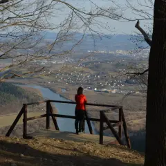 Widok z platformy widokowej na trasie białowodzka góra. Kobieta podziwia panoramę doliny z rzeką i miastem.