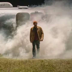 Skubas w dymie, jak kwiat jabłoni, zaraz się zacznie. Mężczyzna wychodzi z przyczepy kempingowej w mglistej scenerii.