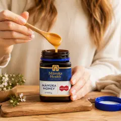 Ktoś nabiera miód manuka na drewnianą łyżkę. Czy miód można trzymać w lodówce? Nie, miód najlepiej przechowywać w temperaturze pokojowej.