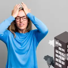 Mujer con las manos en la cabeza, sufriendo por la enfermedad de los edificios. Un edificio con personas en las ventanas emite humo.