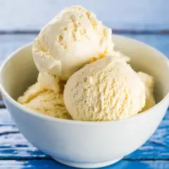 Pyszne, kremowe domowe lody waniliowe w białej miseczce, gotowe do schrupania.