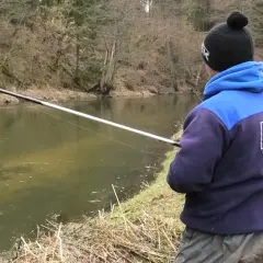 Łowienie z powierzchni na twardy chleb. Jak nie płoszyć kleni i jazi? Wędkarz z wędką nad rzeką.