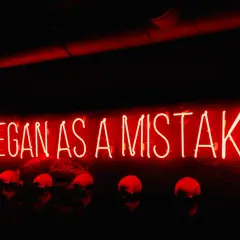Neon rosso "IT BEGAN AS A MISTAKE" sopra teschi. Come si dice "lunedì" in inglese? Monday.