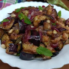 Melanzane in agrodolce, un piatto saporito con cipolle rosse, pinoli e menta fresca.