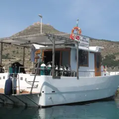 Barca da sub con bombole pronte per il battesimo dello scafo. Sullo sfondo, un castello su una collina.