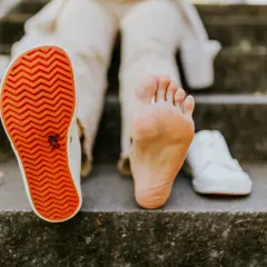 Naga stopa obok buta. **Barefoot co to znaczy**? To wolność i kontakt z podłożem, jak na schodach.