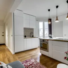 Moderne 50 qm Wohnung einrichten: Offener Wohnbereich mit weißer Küche, Holzboden und Flur.