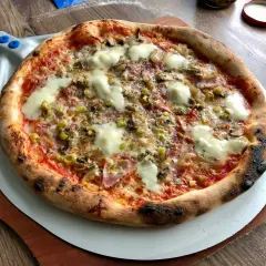 Gorąca, pachnąca prawdziwa pizza z ciągnącym się serem, pieczarkami i oliwkami, prosto z pieca na łopacie.