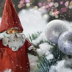 Weihnachtsdeko tipps: Ein Weihnachtsmann mit Stern und Glitzerkugeln auf Tannenzweigen im Schnee.
