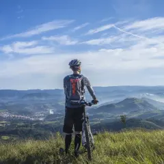 Rowerzysta na szczycie górskiego krajobrazu, podziwiający widok. Przygoda w Beskidach na rowerze.