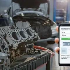 Silnik samochodowy i smartfon z aplikacją do kodów błędów DTC marki Renault.