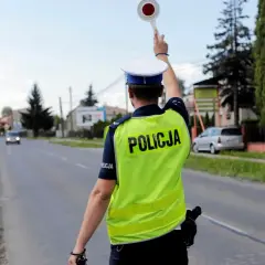 Policjant zatrzymuje ruch, by ukarać kierowcę za przekroczenie prędkości o 30 w terenie zabudowanym.