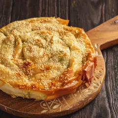 Burek al formaggio, una torta salata a spirale con semi di sesamo, pronta per essere gustata.