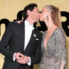 Adrien Brody i jego żona, Georgina Chapman, całują się na ściance.