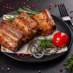 Soczyste żeberka z grilla, podane z marynowaną cebulką, pomidorkiem i rozmarynem. Idealny pomysł na soczyste żeberka!