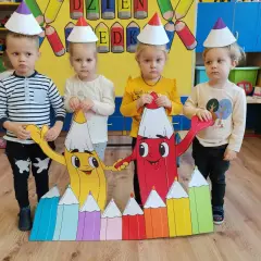 Dzieci w czapkach urodzinowych świętują dzień kredki. Pomysły na kreatywne zabawy z kolorowymi kredkami.