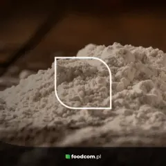 Stos białego proszku, być może mąki, z widocznym logo foodcom.pl. Ten ci 77891 jest idealny do wypieków.