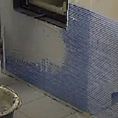 Arbeiter verputzt innen einen Kamin. Ein Eimer mit Mörtel steht bereit.