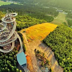 Drewniana konstrukcja sky bridge 721 wije się pośród zielonych lasów, oferując niezwykłe widoki na okolicę.