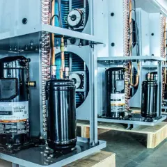 Fila de unidades de aire acondicionado con compresor alternativo en primer plano.